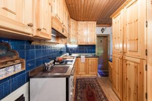 a kitchen with wooden cabinets and a stove top oven at Chalet am Reschensee in Resia +18 photos