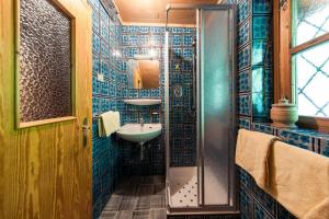 a bathroom with a shower and a sink and a mirror at Chalet am Reschensee in Resia