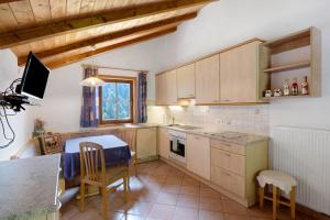 a kitchen with wooden cabinets and a table and chairs at Ausser Brugghof in Senales