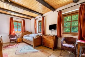 a bedroom with a bed and a tv and windows at Ferienhaus Henneberg in Johanngeorgenstadt
