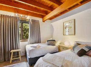 a bedroom with two beds and a window at The Lodge Blackheath in Blackheath