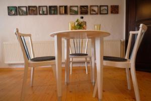 a white table with two chairs and a table with flowers on it at Beim Bildhauer Karl F in Trendelburg