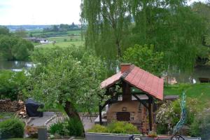 a small house with a red roof in a garden at Beim Bildhauer Karl F in Trendelburg +3 photos