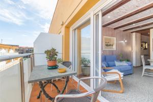 a balcony with a table and chairs and a couch at Apartamento Noenil in L'Estartit
