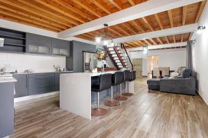 a kitchen and living room with blue cabinets and a bar at Windmill Beach House in Ribeira Grande