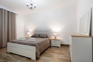 a white bedroom with a bed and two night stands at Windmill Beach House in Ribeira Grande +24 photos