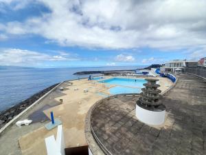 a swimming pool on the edge of the ocean at Windmill Beach House in Ribeira Grande