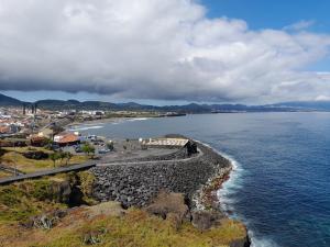 a view of a beach with a town and the ocean at Windmill Beach House in Ribeira Grande