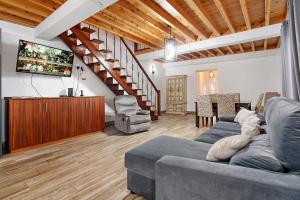 a living room with a gray couch and a tv at Windmill Beach House in Ribeira Grande