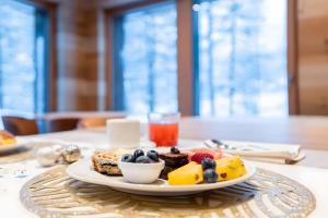 a plate of food with fruit on a table at Chalet Imbosc'chè 5 rooms Bnb in Livigno