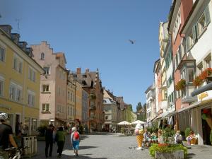 a group of people walking down a street with buildings at Dinkelbach Landhaus 1 B in Lindau-Bodolz +20 photos