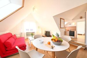a living room with a red couch and a table with fruit on it at Dinkelbach Landhaus 1 B in Lindau-Bodolz