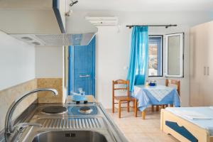 a kitchen with a sink and a table at Studios Ninemia Serifos 4 in Livadi