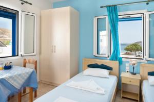 a bedroom with two beds and a table at Studios Ninemia Serifos 4 in Livadi