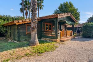 a small house with a palm tree in front of it at Entre Viejos Olivos in Benicolet