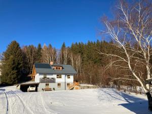 a white house on a snowy hill with trees at Urlaub bei Schönwetter in Raumberg