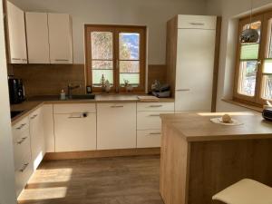 a kitchen with white cabinets and a wooden floor at Urlaub bei Schönwetter in Raumberg