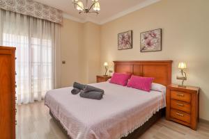 a bedroom with a large bed with pink pillows at Casa Murillo in Nerja
