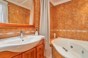 a bathroom with a sink and a tub and a mirror at Casa Murillo in Nerja +18 photos