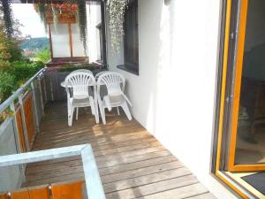 a porch with two chairs and a table on a balcony at Ferienwohnung Braun in Seelfingen