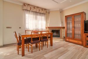 a dining room with a table and chairs and a fireplace at Casa Murillo in Nerja