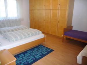a small bedroom with a bed and a blue rug at Ferienwohnung Braun in Seelfingen