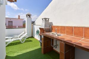 a balcony with a sink and chairs on the grass at Casa Murillo in Nerja
