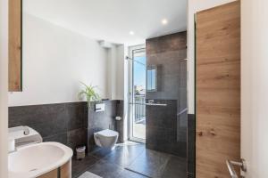 a bathroom with a toilet and a sink and a shower at Modern, Cityview, Penthouse Yiwoo in Gießen +20 photos