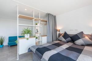 a bedroom with a bed and a blue couch at Modern, Cityview, Penthouse Yiwoo in Gießen