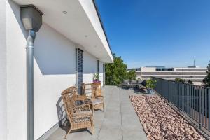 a balcony with two chairs and a table at Modern, Cityview, Penthouse Yiwoo in Gießen