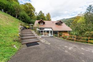 a house on a hill next to a road at Locdecharme in Les Clefs