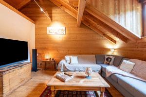 a living room with a couch and a tv at Locdecharme in Les Clefs