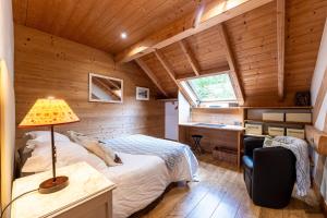 a bedroom in a log cabin with a bed and a desk at Locdecharme in Les Clefs