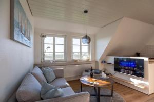 a living room with a couch and a tv at Urlaub an der Nordermühle in Pellworm