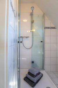 a bathroom with a shower and a pile of towels at Urlaub an der Nordermühle in Pellworm +5 photos