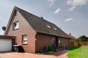 a brick house with a black roof at Ferienwohnung Goesmann in Zetel