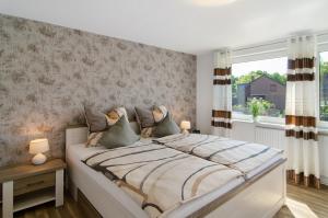 a bedroom with a large bed and a window at Ferienwohnung Goesmann in Zetel