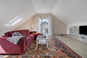 a living room with a red couch and a table at Ferienwohnung Auszeit in Kargow
