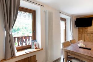 a dining room with a table and a window at Les Cles - Achillea in Valsavarenche