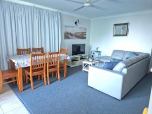 a living room with a couch and a table and a dining room at Dolphin View on South Esplanade in Bongaree