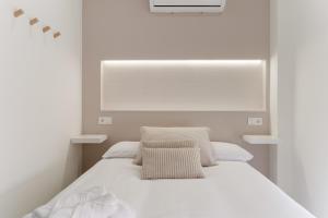 a white bedroom with a bed and a window at Cala Sol - few steps from the beach in La Cala de Mijas