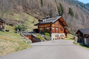 a large wooden house on a hill next to a road at Mas Di Zonadi in Rabbi