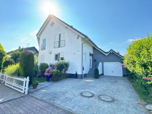 a white house with a driveway at Hochwertige Ferienwohnung Ötigheim in Ötigheim