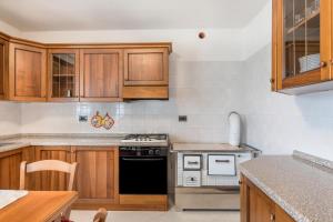 a kitchen with wooden cabinets and a stove top oven at Appartamento dorsino in Dorsino