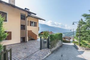 a house with a gate on a brick road at Appartamento dorsino in Dorsino