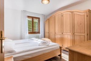 a bedroom with a bed and a wooden cabinet at Appartamento dorsino in Dorsino