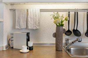 a kitchen counter with a vase of flowers and a sink at Studio Apartment 1 Min From Lake in Como +21 photos