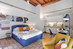 a bedroom with a blue bed and a kitchen at Studio Apartment 1 Min From Lake in Como