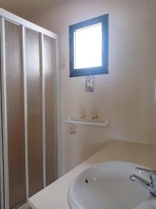 a white bathroom with a sink and a window at Apartment Niceview in Alaior +10 photos