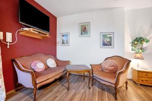 a living room with two chairs and a flat screen tv at Comic Fantasy in Lindau